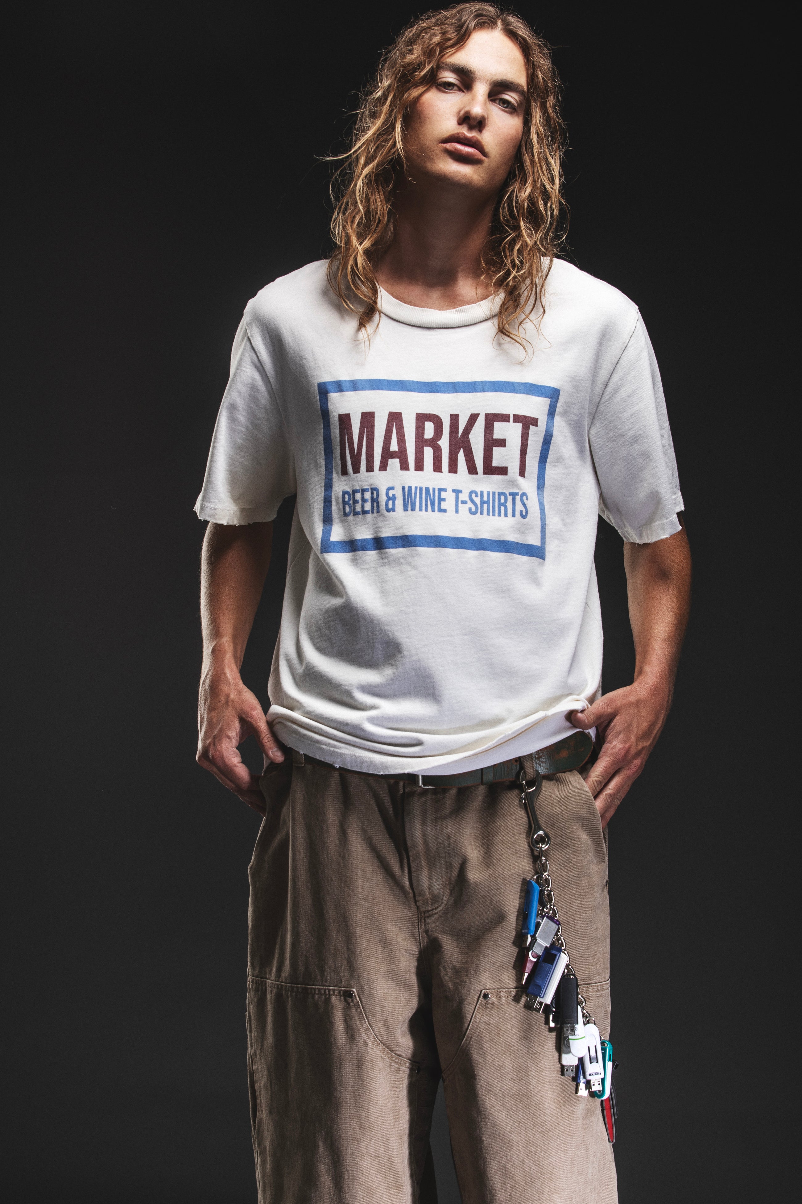 Person wearing a white t-shirt with 'Market Beer & Wine T-Shirts' text on a black background